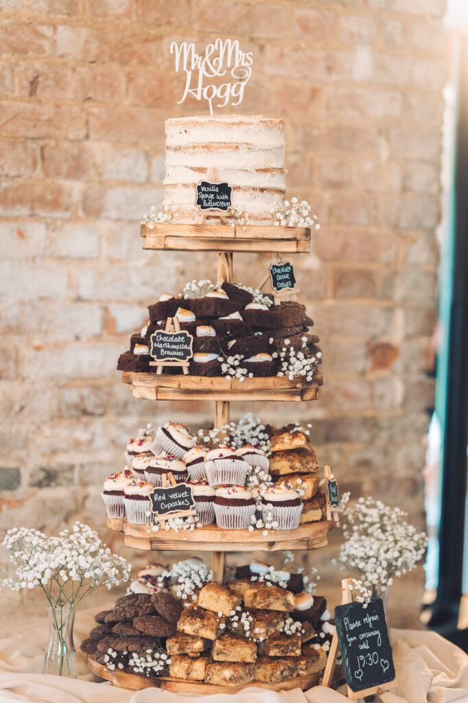 Four tiered display of wedding cakes comprising of different homemade sweet options for guests
